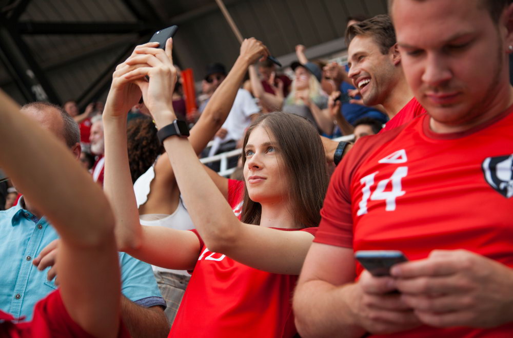 Cricket fan using smartphone at stadium